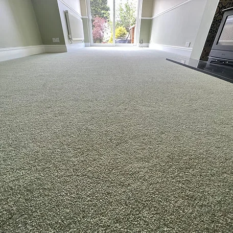 A living room floor featuring a soft green carpet installed by Carpet and Vinyl in the Cotswolds and Southwest